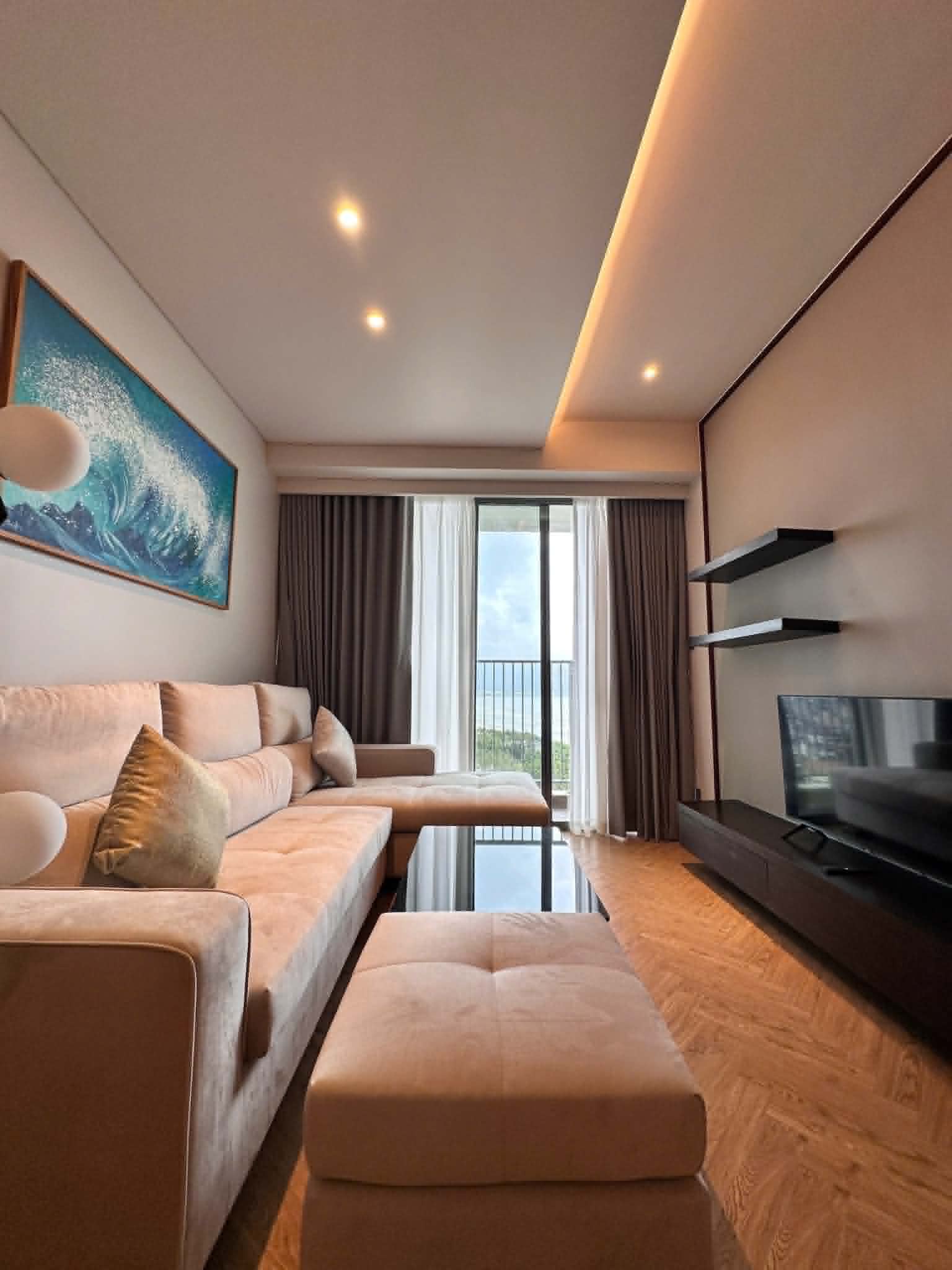 Warm living room with velvet sofa and sea view balcony